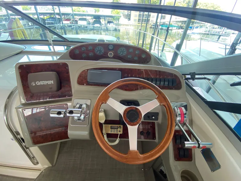 Slide: The Image of 1998 Maxum 3700 SCR boat helm with Garmin navigation, wood accents, and steering wheel. - 13