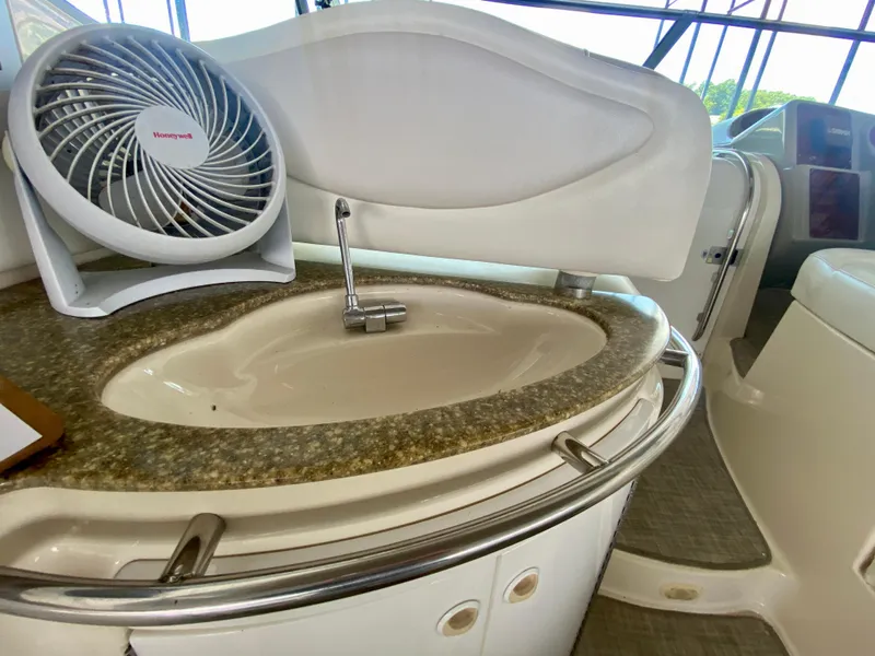 Slide: The Image of 1998 Maxum 3700 SCR yacht interior with sink and fan on countertop. - 17