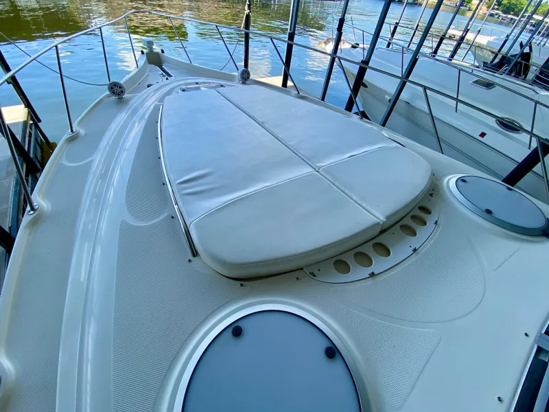 Slide: The Image of 1998 Maxum 3700 SCR boat deck with cushioned seating, docked by the water. - 18