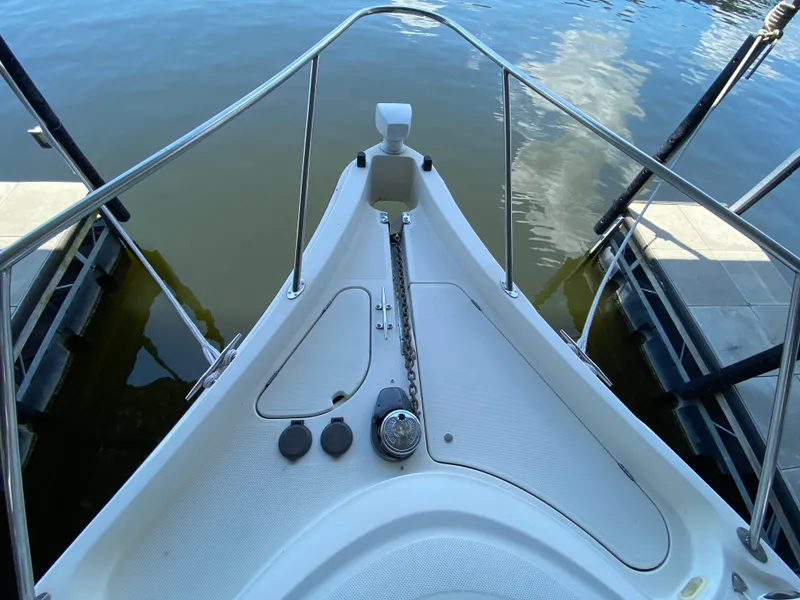 Slide: The Image of Bow of 1998 Maxum 3700 SCR boat with anchor chain, docked on calm water. - 20