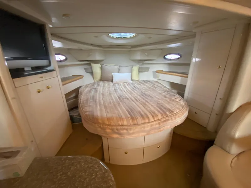 Slide: The Image of 1998 Maxum 3700 SCR yacht interior with cozy bed, TV, and storage cabinets. - 29
