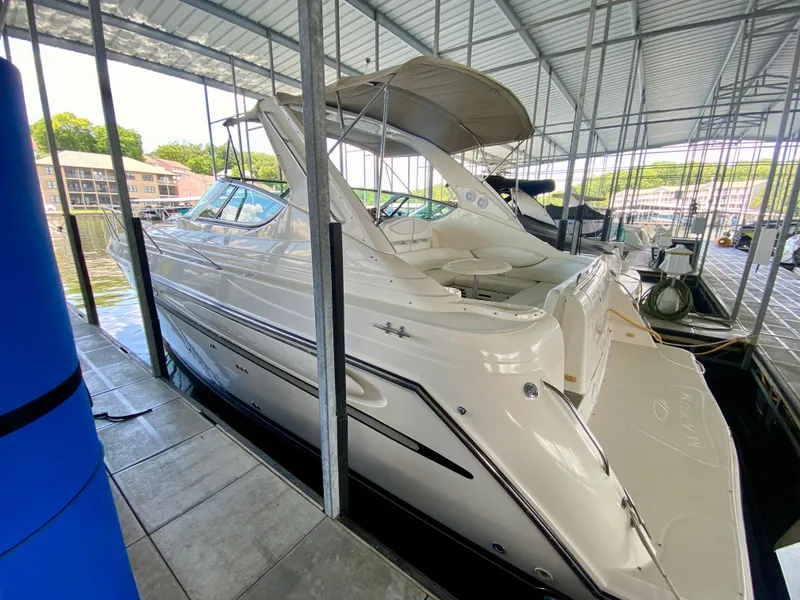 Slide: The Image of 1998 Maxum 3700 SCR yacht docked in a covered marina. - 3