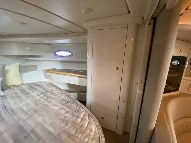 Slide: The Image of 1998 Maxum 3700 SCR cabin interior with bed, storage, and porthole window. - 31