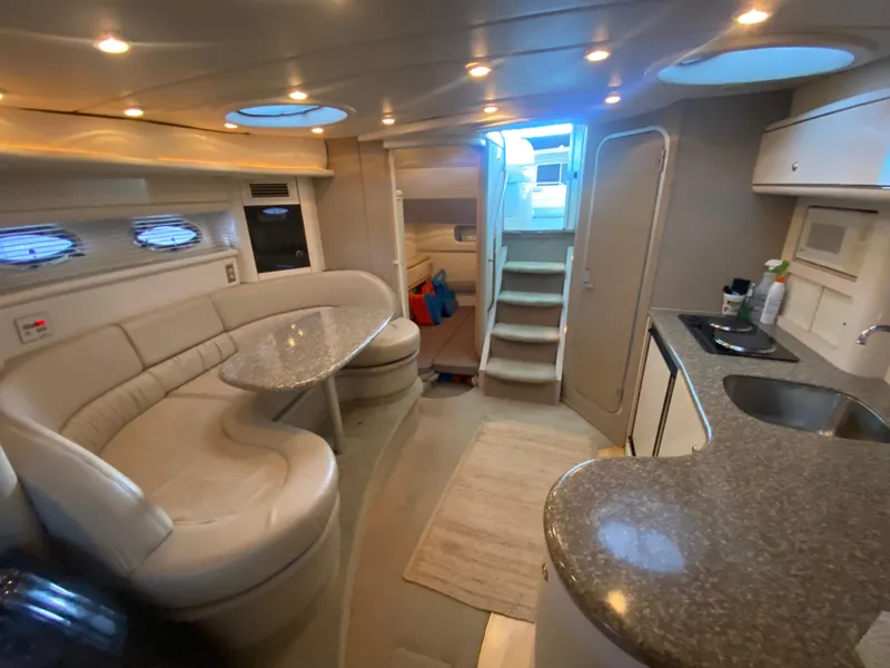Slide: The Image of Interior of 1998 Maxum 3700 SCR yacht with modern seating and kitchenette. - 34