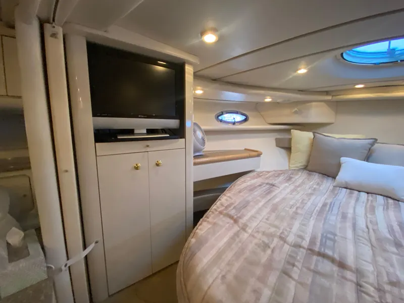Slide: The Image of 1998 Maxum 3700 SCR cabin interior with bed, TV, and porthole windows. - 45