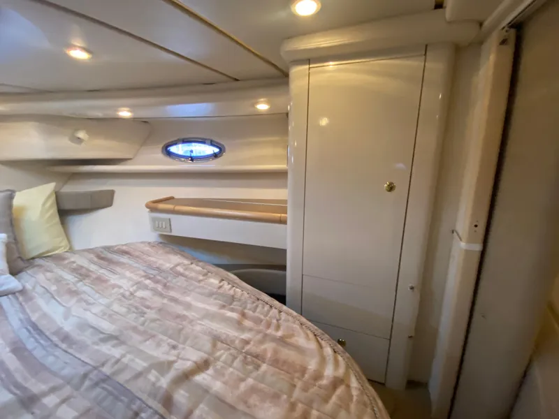Slide: The Image of 1998 Maxum 3700 SCR cabin interior with bed, storage, and porthole window. - 46