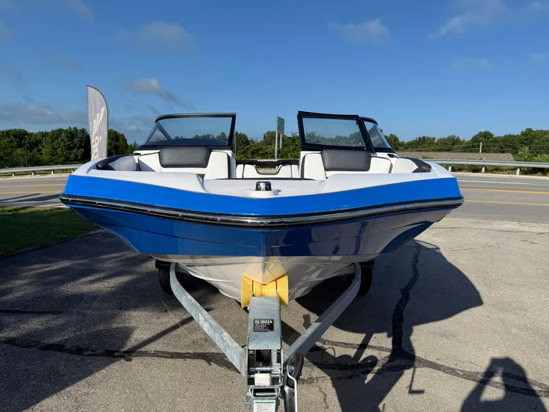 Slide: The Image of 2025 Yamaha SX195 boat on trailer, blue and white design, parked outdoors. - 3