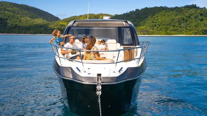 Slide: The Image of 2025 NX Boats NX50 Invictus HT cruising with passengers on a scenic blue water backdrop. - 29