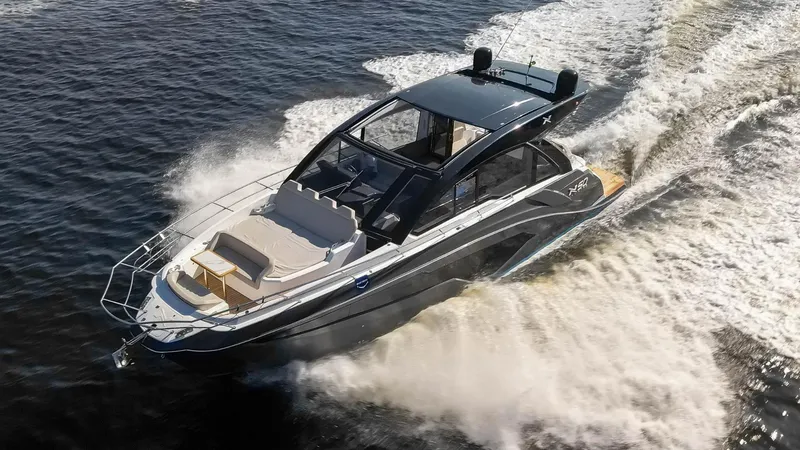 Slide: The Image of 2025 NX Boats NX50 Invictus HT cruising on water, showcasing sleek design and powerful performance. - 3