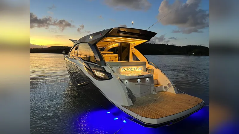 Slide: The Image of 2025 NX Boats NX50 Invictus HT yacht illuminated at sunset on calm waters. - 30