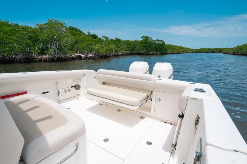 Slide: The Image of 2019 Boston Whaler 330 Outrage boat on a serene river with lush greenery. - 12