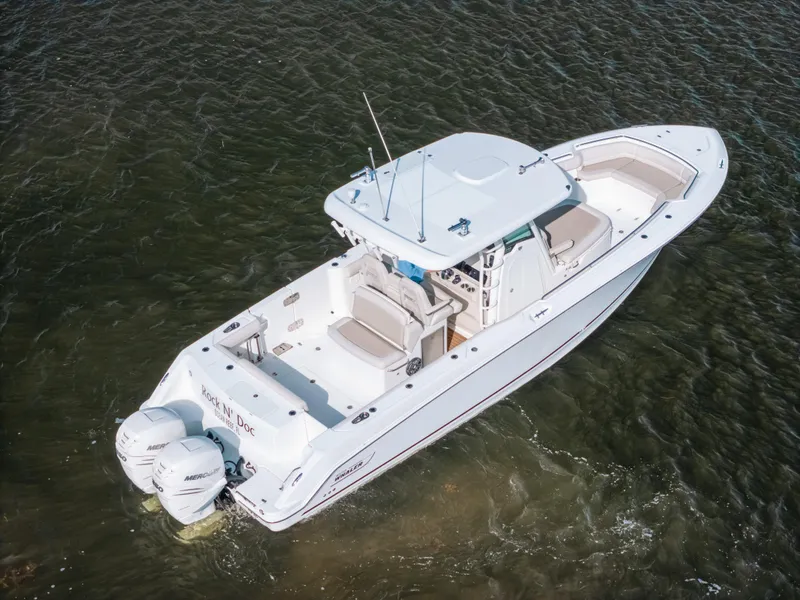 Slide: The Image of 2019 Boston Whaler 330 Outrage boat on water, featuring dual Mercury engines. - 16