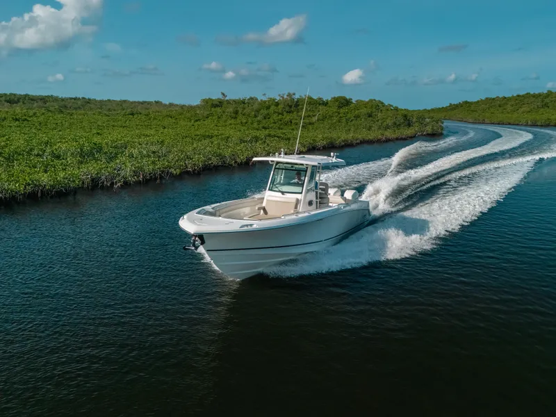 Slide: The Image of 2019 Boston Whaler 330 Outrage cruising on a scenic waterway. - 24
