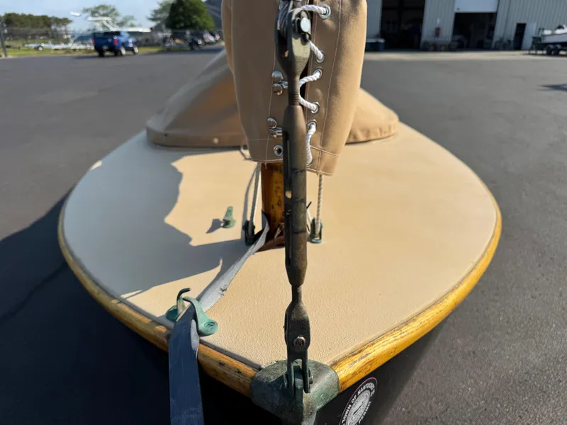Slide: The Image of Custom 2004 Barnstable Cat Boat with tan cover, docked on asphalt surface. - 10