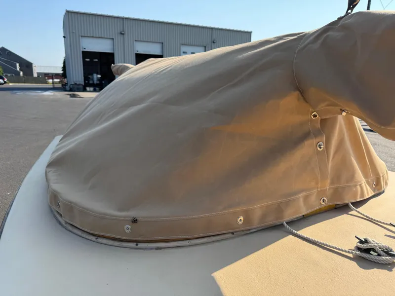 Slide: The Image of 2004 Custom Barnstable Cat Boat with tan cover in a marina setting. - 11