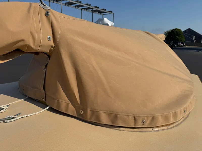 Slide: The Image of Tan canvas cover on a 2004 Custom Barnstable Cat Boat, secured with metal fasteners. - 12