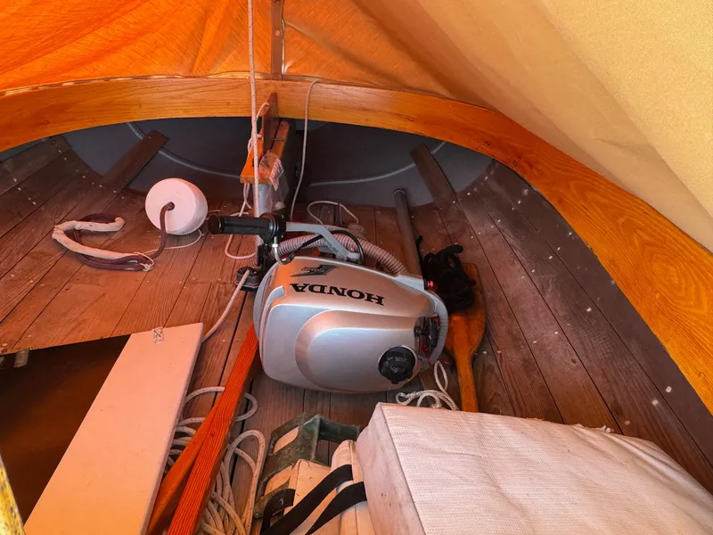 Slide: The Image of Interior of a 2004 Custom Barnstable Cat Boat with Honda motor and wooden flooring. - 6