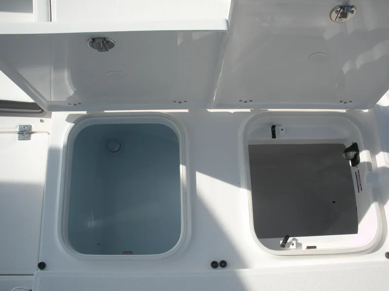 Slide: The Image of 2026 Robalo R246 Caymann boat storage compartments open, showcasing interior design. - 13