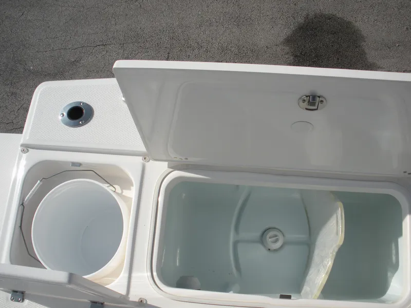 Slide: The Image of 2026 Robalo R246 Caymann boat storage compartments open, showing interior details. - 16