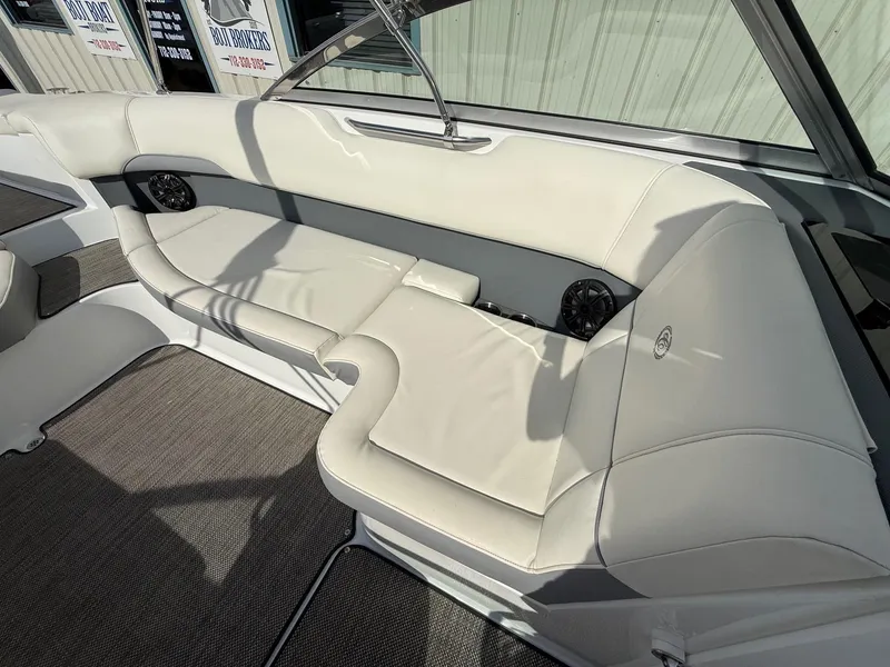 Slide: The Image of 2015 Cobalt 220 boat interior with white leather seating and speaker system. - 15