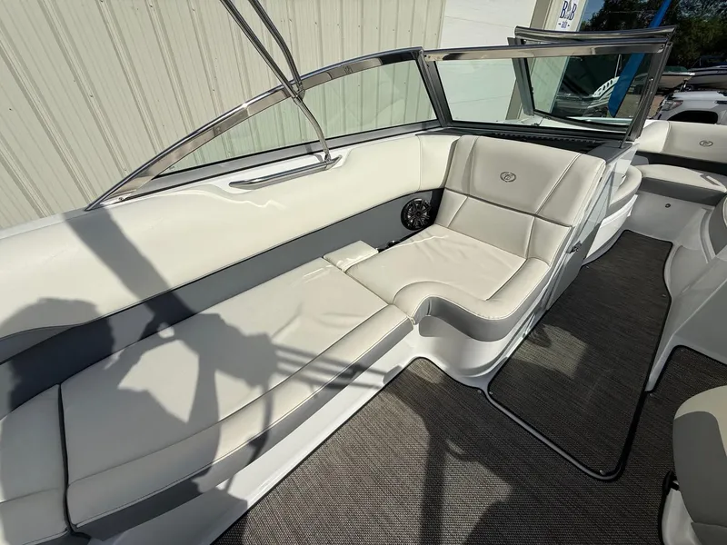 Slide: The Image of 2015 Cobalt 220 boat interior with white leather seating and carpeted flooring. - 17
