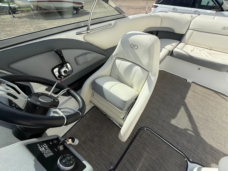 Slide: The Image of Interior of a 2015 Cobalt 220 boat featuring steering wheel and seating. - 22