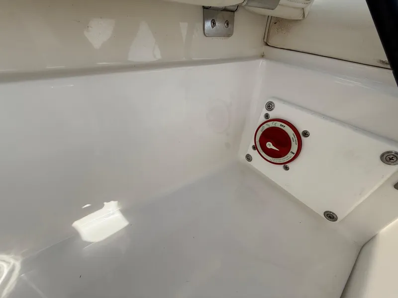 Slide: The Image of 2015 Cobalt 220 boat battery switch in white compartment. - 26
