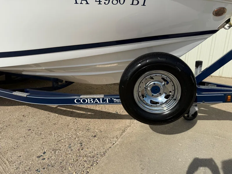 Slide: The Image of 2015 Cobalt 220 boat on trailer with visible wheel and registration number. - 29