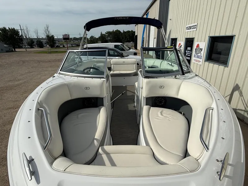 Slide: The Image of 2015 Cobalt 220 boat with white interior, parked outside a building. - 3