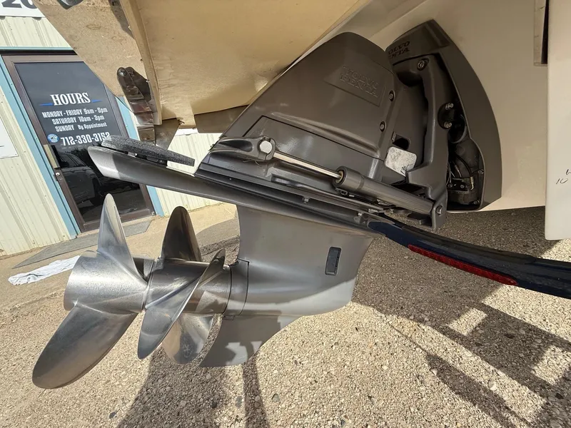 Slide: The Image of 2015 Cobalt 220 boat propeller and outdrive close-up in a parking area. - 6