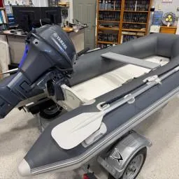 Slide: The Image of 2022 West Marine Compact Rib-310 inflatable boat with motor on trailer in showroom. - 3