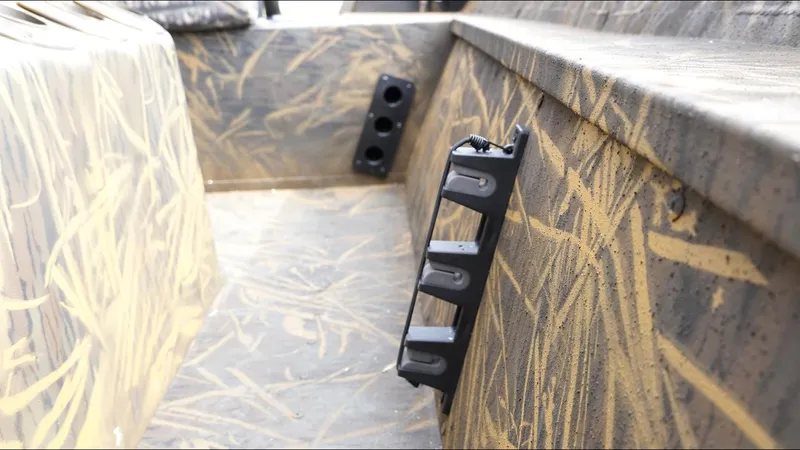 Slide: The Image of 2025 G3 Bay 17 boat interior with camouflage design and rod holders. - 14