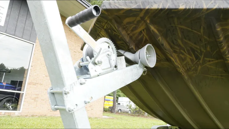 Slide: The Image of Winch mechanism on a 2025 G3 Bay 17 boat trailer, outdoors near a building. - 26