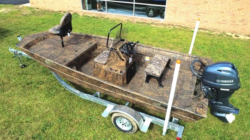 Slide: The Image of 2025 G3 Bay 17 boat with Yamaha motor on trailer, camo design, parked on grass. - 4