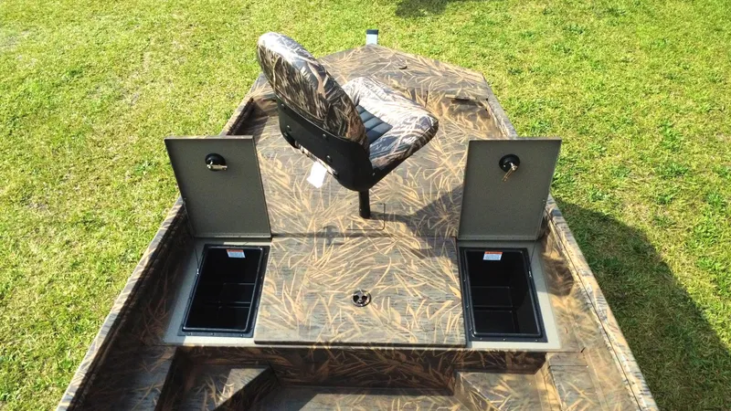 Slide: The Image of 2025 G3 Bay 17 boat interior with camo seat and storage compartments on grass. - 5