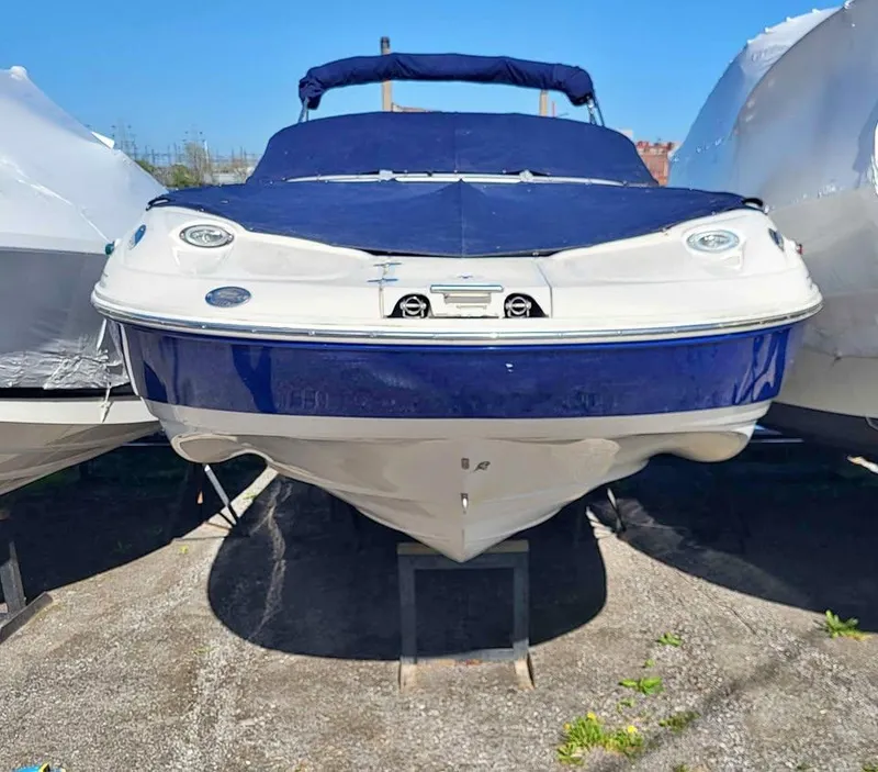 Slide: The Image of 2005 Monterey 263 ES Explorer boat with blue cover, parked on a stand. - 1