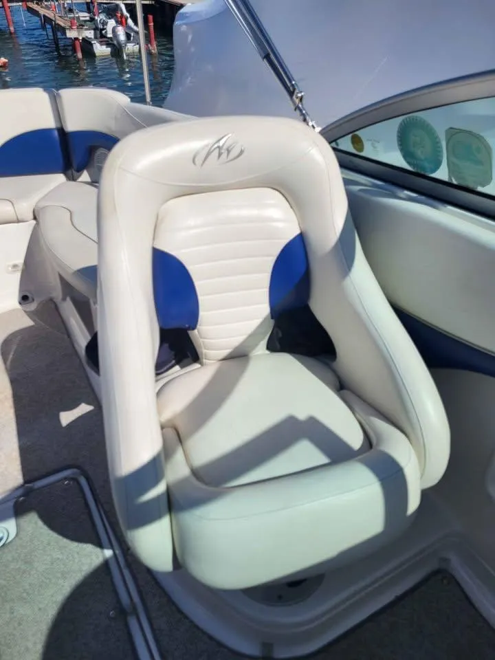 Slide: The Image of Luxury seating on a 2005 Monterey 263 ES Explorer boat, featuring white and blue upholstery. - 11