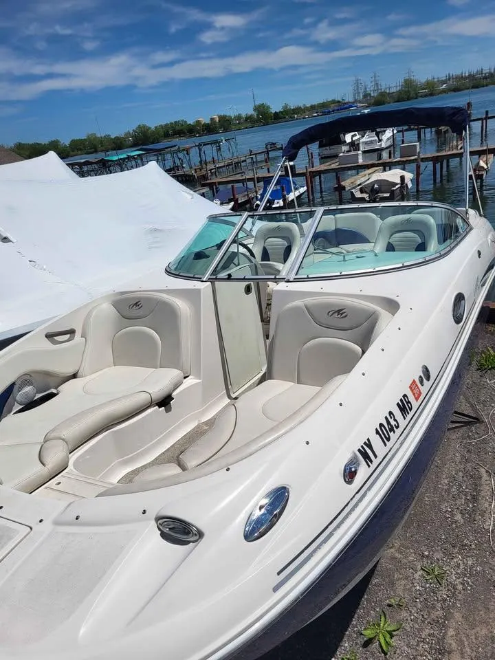 Slide: The Image of 2005 Monterey 263 ES Explorer boat docked by the lake under a clear blue sky. - 16