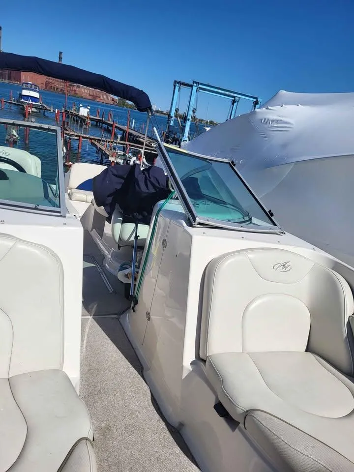 Slide: The Image of 2005 Monterey 263 ES Explorer boat interior with seating, docked by the water. - 2