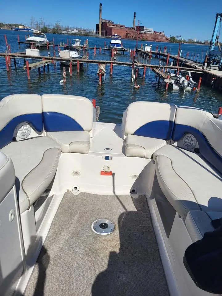 Slide: The Image of 2005 Monterey 263 ES Explorer boat interior with dock and industrial backdrop. - 9