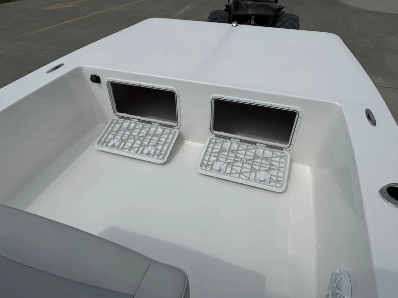 Slide: The Image of 2025 Bay Rider 2060 Skiff boat storage compartments open on deck. - 10