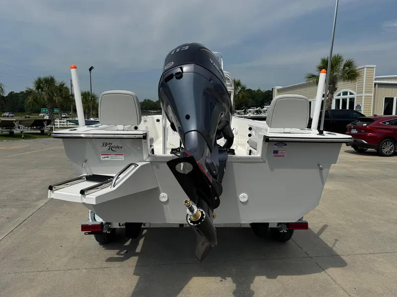 Slide: The Image of 2025 Bay Rider 2060 Skiff with outboard motor, parked outdoors. - 4