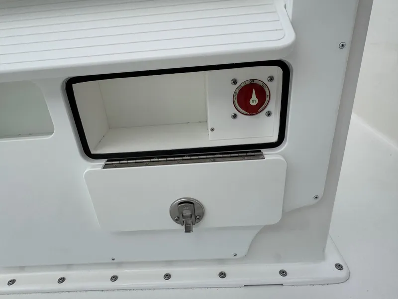 Slide: The Image of Bay Rider 2060 Skiff 2025 boat compartment with red switch and secure latch. - 18