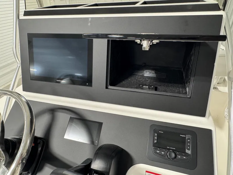 Slide: The Image of 2026 Bay Rider 2260 FS Skiff dashboard with Garmin display and storage compartment. - 17