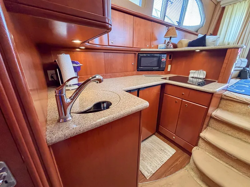 Slide: The Image of Luxurious 2007 Silverton 38 Convertible yacht kitchen with modern amenities and elegant wood finish. - 18