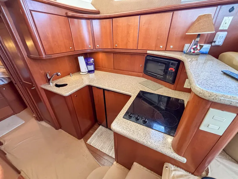 Slide: The Image of 2007 Silverton 38 Convertible yacht kitchen with wood cabinets, stove, microwave, and sink. - 19