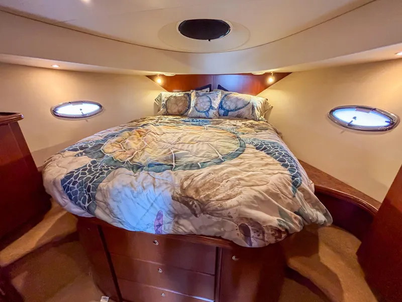 Slide: The Image of Luxurious 2007 Silverton 38 Convertible yacht bedroom with cozy bedding and elegant wood finishes. - 21