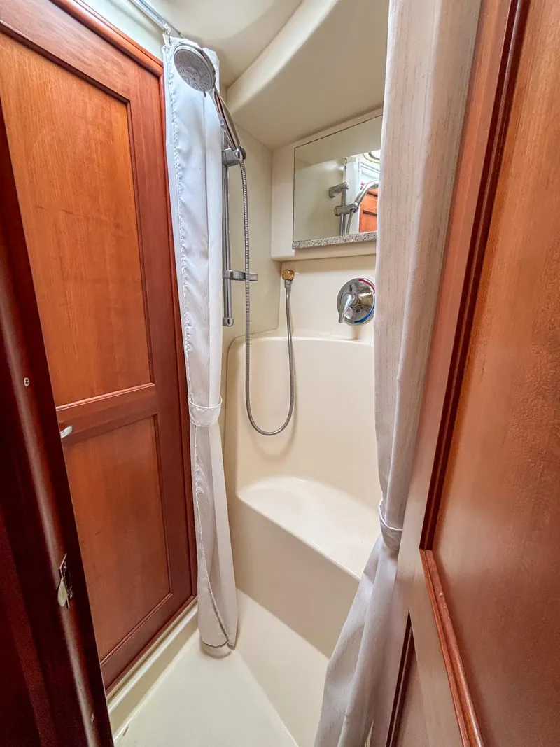 Slide: The Image of Shower area in 2007 Silverton 38 Convertible yacht with wooden accents and curtain. - 26
