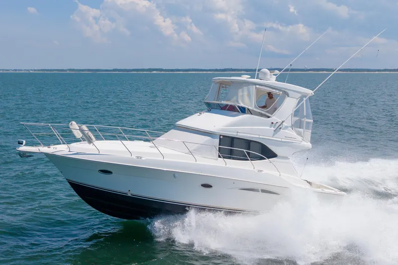 Slide: The Image of 2007 Silverton 38 Convertible yacht cruising on open water under a clear sky. - 32