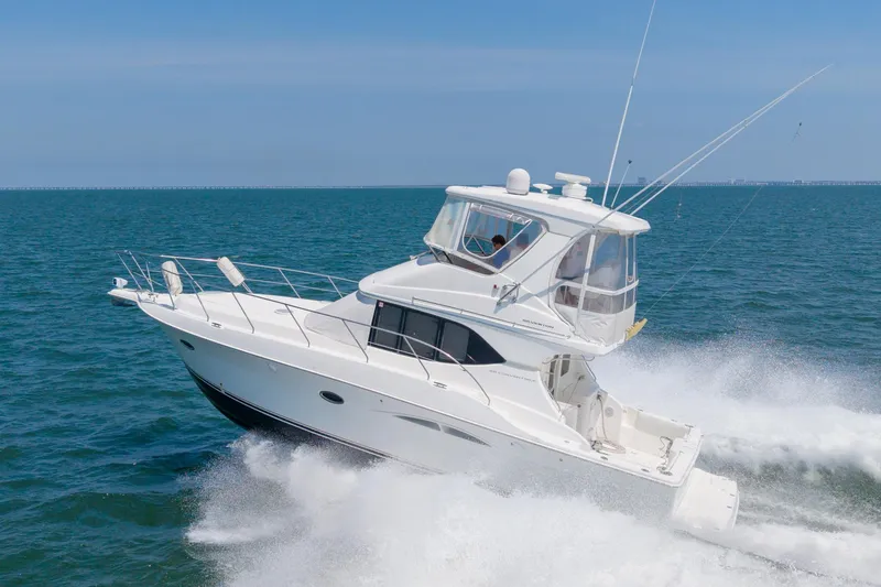 Slide: The Image of 2007 Silverton 38 Convertible yacht cruising on open sea, creating waves. - 33